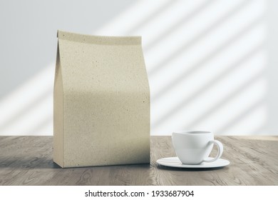 Recycled Paper Coffee Package With Copyspace And White Tea Cup On Wooden Table In The Morning. Mockup, 3D Rendering