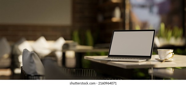 Remote Working Space Concept, Notebook Laptop Computer Blank Screen Mockup And Coffee Cup On A Table In Modern Cafe Seating Area Interior Design. 3d Rendering, 3d Illustration