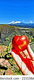A ripe apple the fingers one hand and the landscape snow capped mountains in the background 