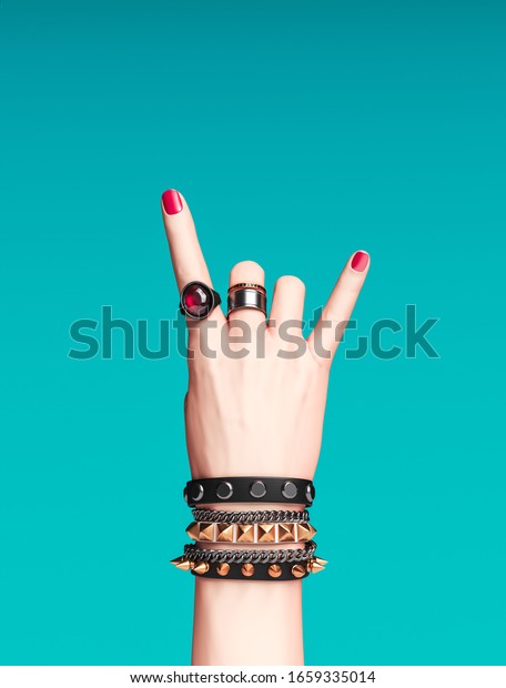 ロックハンドサイン 女性の手のパンクロックジェスチャー 金色の手首ブレスレットと指輪 クリエイティブアートの抗議バナー ファッションヒップスターのアクセサリー 3dレンダリング の イラスト素材