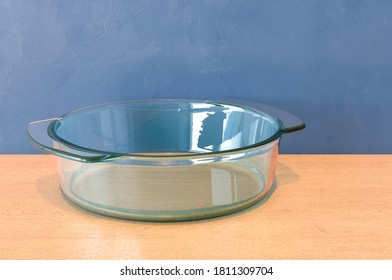 Round Clear Glass Baking Dish On The Wooden Table. 3D Rendering