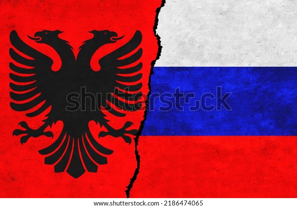 Russia and Albania painted flags on a wall with\
a crack. Russia and Albania relations. Albania and Russia flags\
together