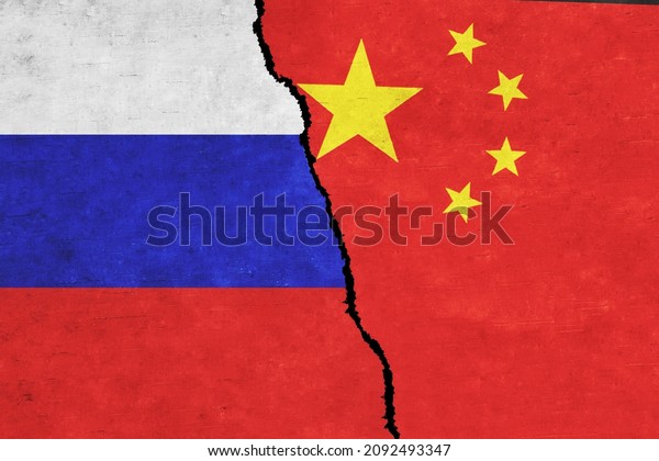 Russia and China painted flags on a wall with a\
crack. Russia and China relations. China and Russia flags together.\
Russia vs China