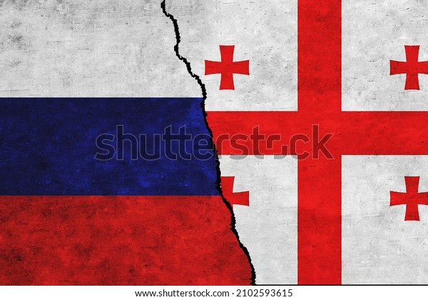 Russia and Georgia painted flags on a wall with\
a crack. Russia and Georgia conflicts. Georgia  and Russia flags\
together