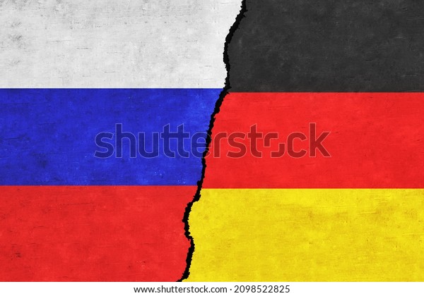 Russia and Germany painted flags on a wall with a\
crack. Russia and Germany relations. Germany and Russia flags\
together. Russia vs\
Germany