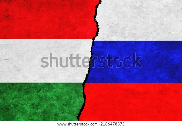 Russia and Hungary painted flags on a wall with\
a crack. Russia and Hungary relations. Hungary and Russia flags\
together