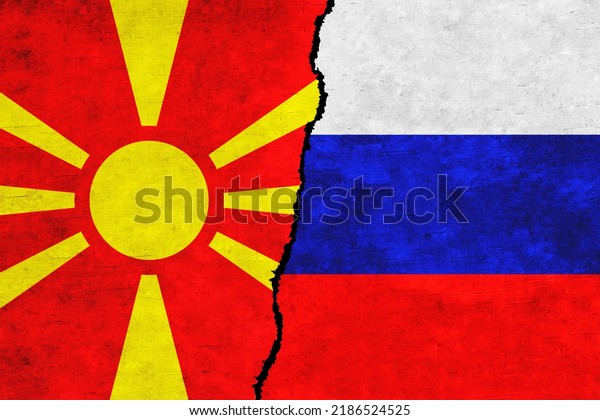 Russia and North Macedonia painted flags on a\
wall with a crack. Russia and North Macedonia relations. North\
Macedonia and Russia flags\
together