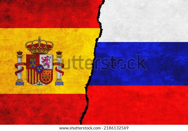 Russia and\
Spain painted flags on a wall with a crack. Russia and Spain\
relations. Spain and Russia flags\
together