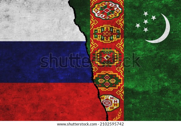 Russia and Turkmenistan painted flags on a wall\
with a crack. Russia and Turkmenistan relations. Turkmenistan  and\
Russia flags\
together