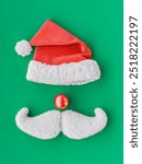 Santa claus hat, mustache and red nose on green background composing a christmas character. 3d rendering