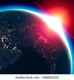Satellite view of the Earth seen from space. The sun rising over the Middle East, India. Cities illuminated in the night. Sunrise
