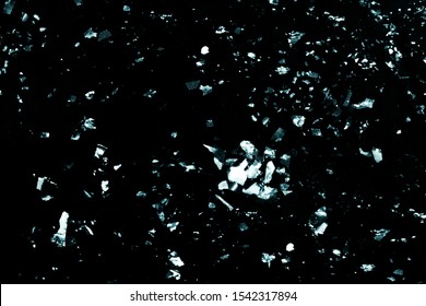 Scattered Chunky Light Blue Glitter Pieces Of Various Sizes Isolated On A Black Background.