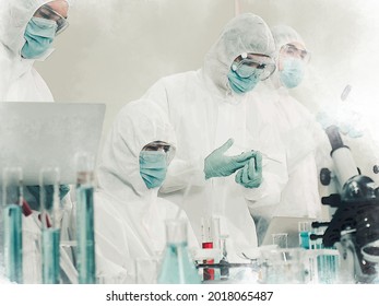 Scientists Working In Scientific Laboratory. Doctor Team Wear Personal Protective Equipment Suit Research And Analyzing Vaccine In Virology. Researcher Wear PPE Medical Clothes For Virus Protection.