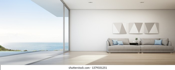 Sea View Living Room Of Luxury Summer Beach House With Swimming Pool And Wooden Terrace. Big Gray Sofa In Vacation Home Or Holiday Villa. Hotel Interior 3d Illustration.