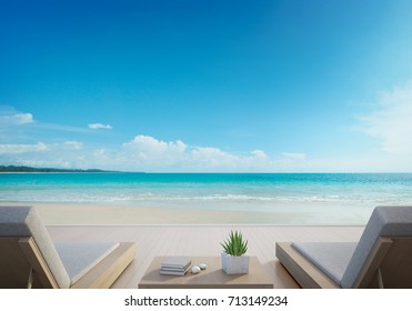 Sea view terrace and beds in modern luxury beach house with blue sky background, Lounge chairs on wooden deck at vacation home or hotel - 3d illustration of tourist resort - Powered by Shutterstock