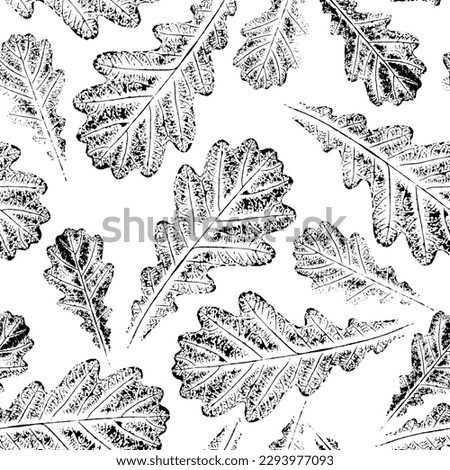 Seamless pattern with oak leaves. Silhouettes of large and small falling leaves with streaked black on a white background. Pattern of ink impressions of leaf texture. 