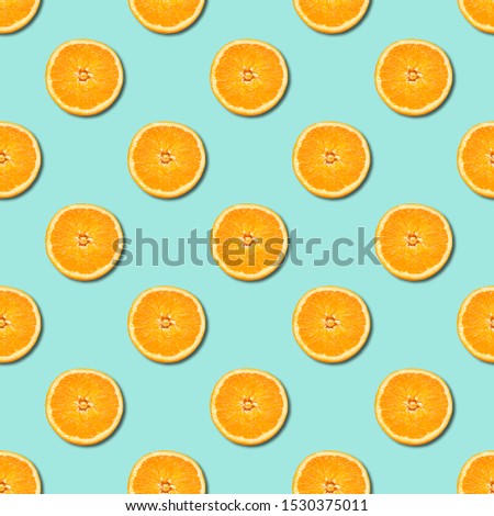 Seamless pattern of orange sliced on neo mint green color background. Minimal, flat lay, food texture.