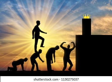 A Selfish Man Walks The Heads Of People As On The Steps To The Highest Post Behind The Crown. Conceptual Scene Is A Narcissistic And Selfish Person