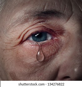 Senior depression and elderly mental health issues related to loneliness and emotional illness based on grief or chemical imbalance as anxiety in a close up of an aging human eye crying a tear drop.