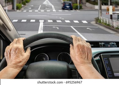 Senior woman driving a car on street in city. - Powered by Shutterstock