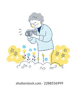 Senior woman photographing flowers in the garden - Powered by Shutterstock