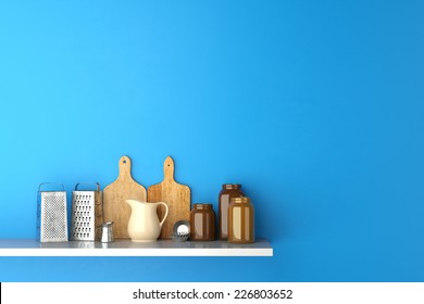 Shelf In Kitchen With Cutting Boards And Kitchenware On A Blue Wall (3D Rendering)