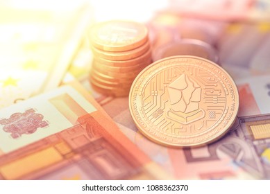 shiny golden LISK cryptocurrency coin on blurry background with euro money