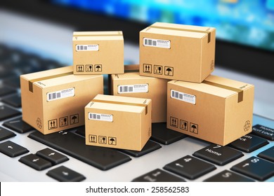 Shipping, Delivery And Logistics Technology Business Industrial Concept: Macro View Of Heap Of Stacked Corrugated Cardboard Package Boxes On Computer PC Laptop Notebook Keyboard With Selective Focus