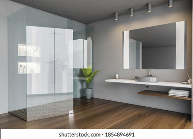 Shower Cabin In Grey Bathroom With Sink And Towels, And Mirror. Dark Open Space Bathroom With Plant, Wooden Floor. Minimalist Luxury Bathroom, 3D Rendering No People