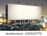 Side view of empty poster on illuminated night city background. Advertisement concept. 3D Rendering