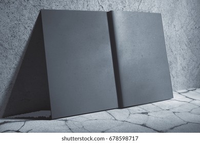Side view of open gray hardcover notebook leaning on concrete wall. Abstract supplies, stationery items. Mock up, 3D Rendering 