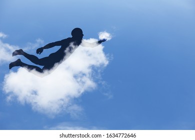 Silhouette of a boy playing with a puff of cloud while floating in the sky for the fantasy concept of playing with your dream. 