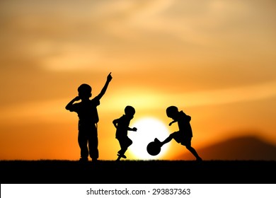 silhouette  brothers, boys play football at sunset.