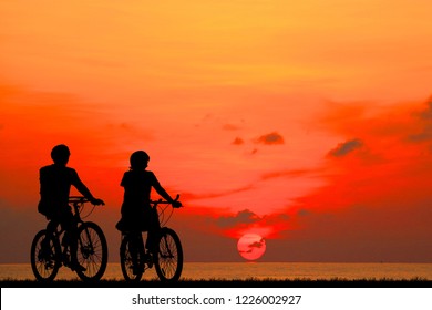 silhouette couple ride bike on sunrise - Powered by Shutterstock