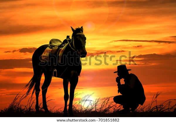 夕焼けの曇った夕空にカウボーイと馬のシルエット のイラスト素材
