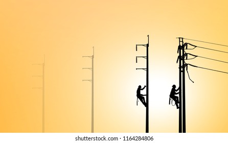 Silhouette Electrical Engineers Working On Electricity Pylon High Tension Power Line Repairs And Maintenance  On Blurry Sunset Background