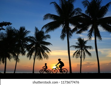 silhouette Father and son riding bicycle at sunset sky - Powered by Shutterstock