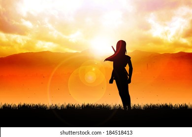 Silhouette of a female figure with katana sword standing in front of the mountain