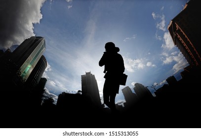 Silhouette of a female office worker against an urban surrounding for the concept of city living. - Powered by Shutterstock