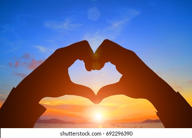 silhouette heart shape with hands on sunset - Powered by Shutterstock