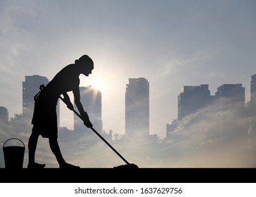 Silhouette of a lady cleaner mopping the floor against a surreal urban landscape for the concept of the scrubbing for a living in the city.  - Powered by Shutterstock