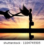 Silhouette of a large hand with scissors intends to prune the wings of a man. Business concept