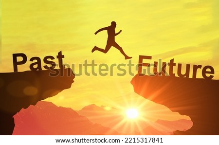 Silhouette man jump between Past and Future years over sun and through on gap of hill evening sky. Symbol of starting. Go ahead and Keep go on to success