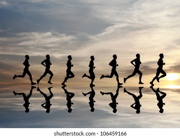 Silhouette of runner with reflection during a surreal dramatic sunset.