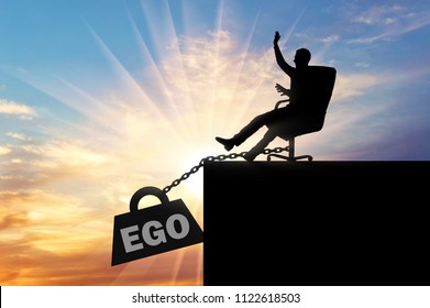 Silhouette Of A Selfish Boss Sitting In A Chair And A Heavy Load Of Ego, Pulling Him Into The Abyss. Conceptual Scene Of Selfishness