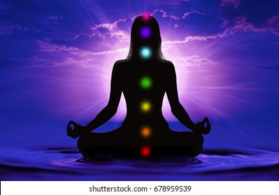 Silhouette of woman doing yoga and where has scored seven chakra points