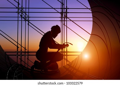 A silhouette of a worker-welder.