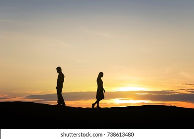 Silhouettes of couple man and woman broken heart. In nature sunset. Love concept.