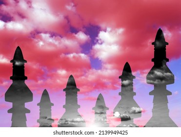 Silhouettes of military rockets against the sky with red clouds. The concept of militarization and military conflicts.