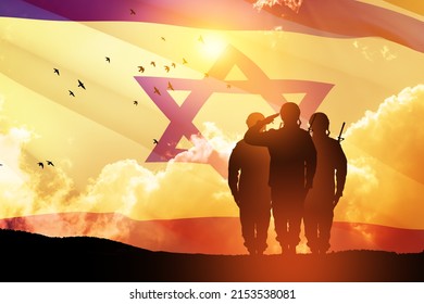 Silhouettes of soldiers saluting against the sunrise in the desert and Israel flag. Concept - armed forces of Israel.